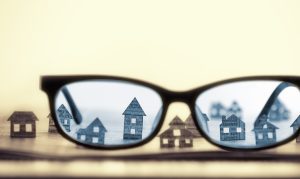 Lens of glasses showing houses