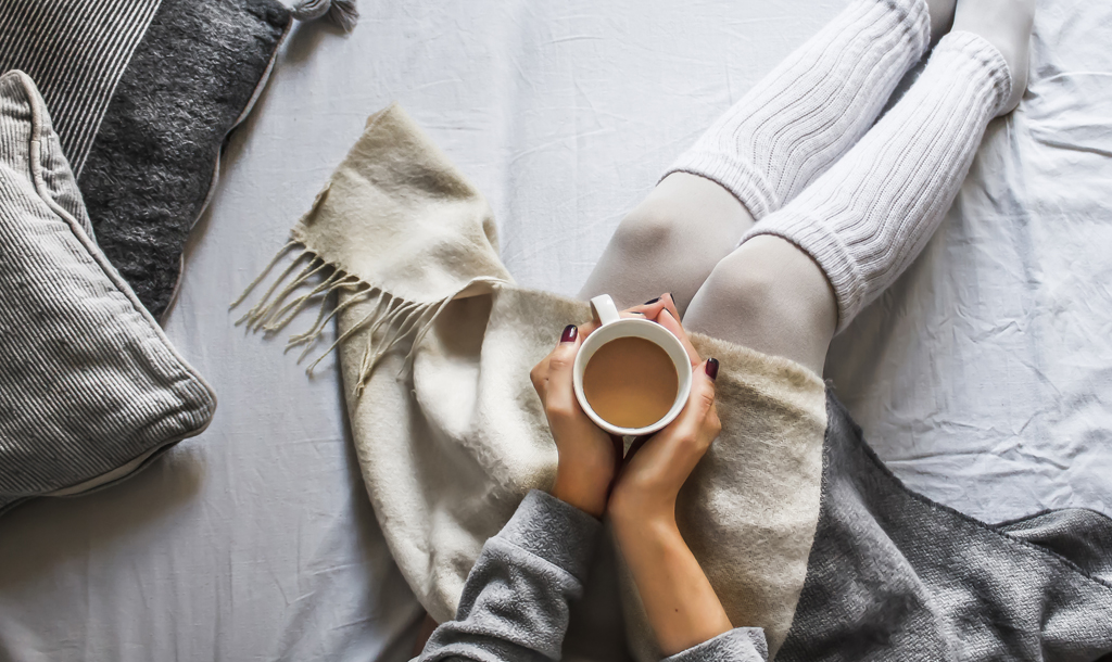Woman warming herself at home with a cup of tea