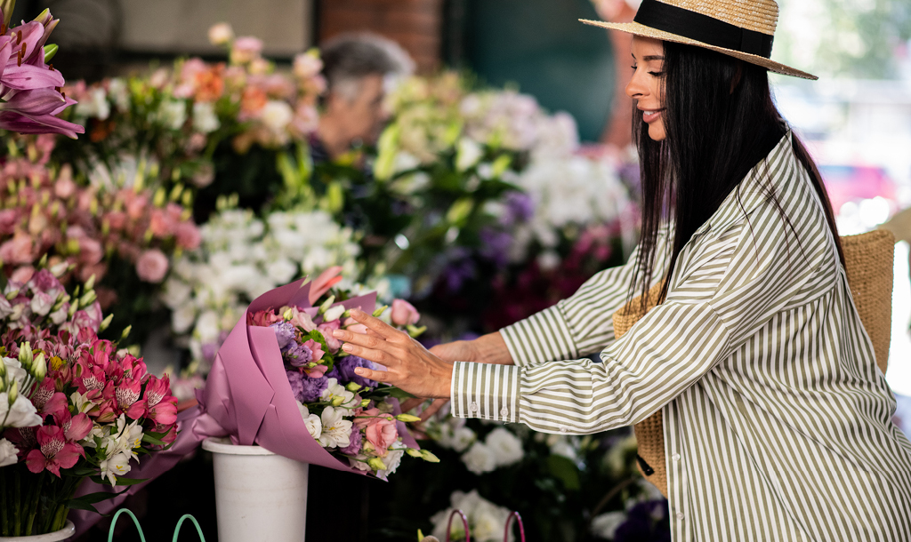 Woman choosing a bouquet at a flower stall.